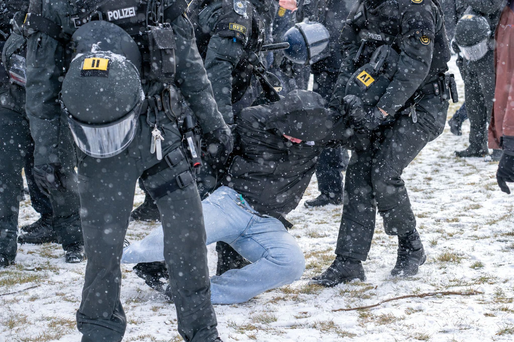 Polizisten ergreifen einen Teilnehmer einer Demonstration auf dem Königsplatz. — © Pia Bayer/dpa