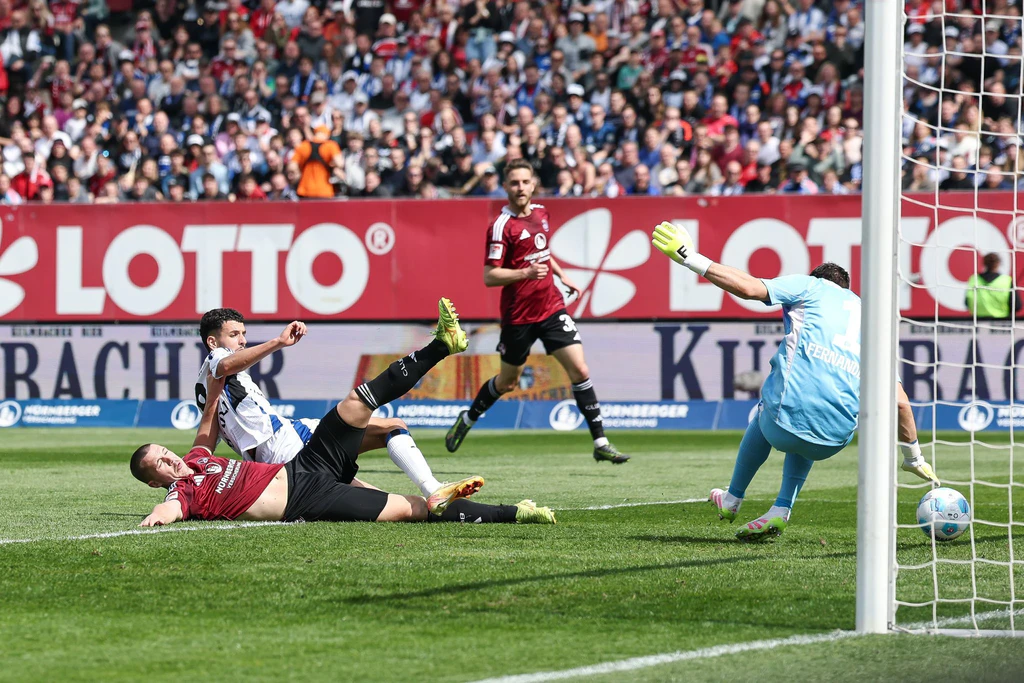 Die Großchance zum 1:1 für Nürnberg: Ondrej Karafiat (l) scheitert im Fallen an HSV-Torwart Daniel Heuer Fernandes. — © Daniel Löb/dpa