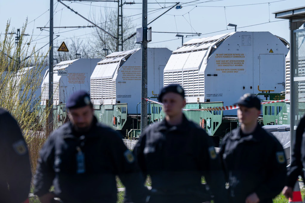 Polizisten sichern einen Zug mit Castor-Behältern ab. — © Armin Weigel/dpa